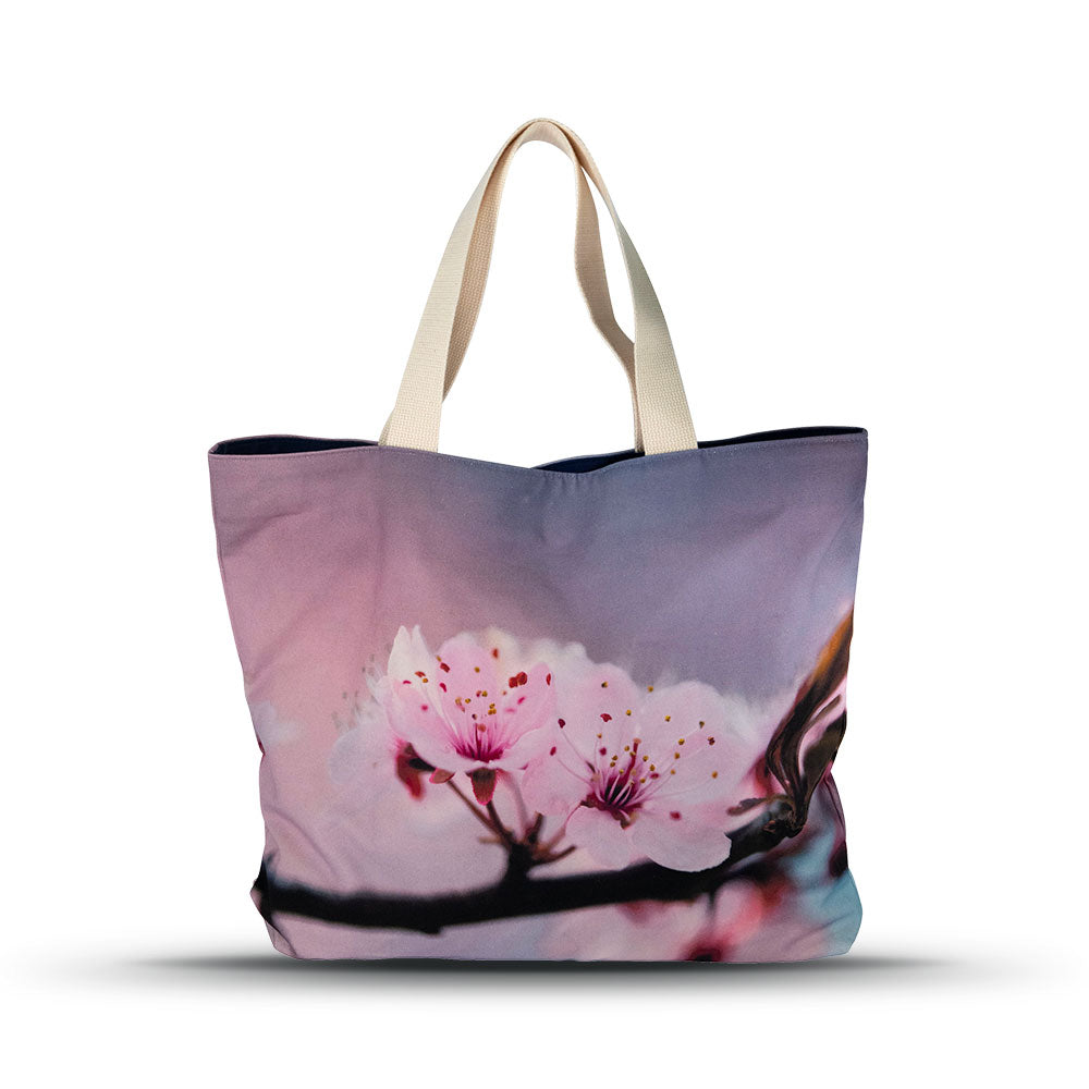 cherry blossoms on a pink and light purple background of the market tote with a white background