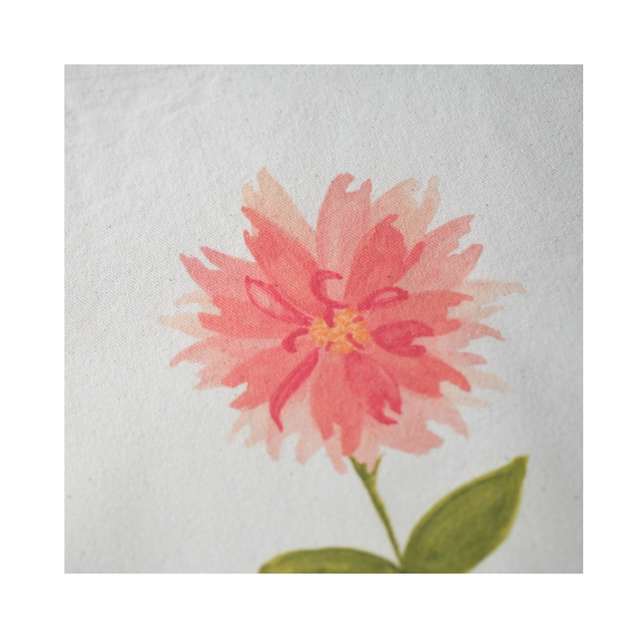 Close-up of A Little Bit Sassy watercolor artwork printed on natural canvas, showing layered coral and peach petals, a small yellow center, and green leaves against the textured fabric.