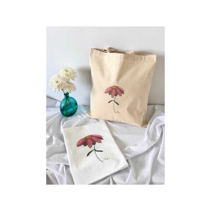 Natural canvas tote bag and matching tea towel featuring the original watercolor painting Better Together displayed with white flowers in a turquoise glass vase.