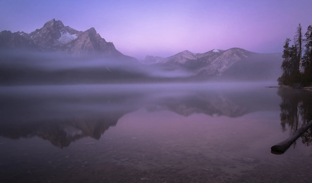 Long exposure reflection of Sawtooth Mountains in fog at Little Redfish Lake, Idaho at sunrise.