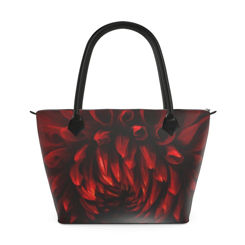 Crimson dahlia zip top handbag with rich red swirling petals on a dark background, structured silhouette with black leather handles and top zipper closure, botanical art design by Sally Halvorsen. Monroe Satin