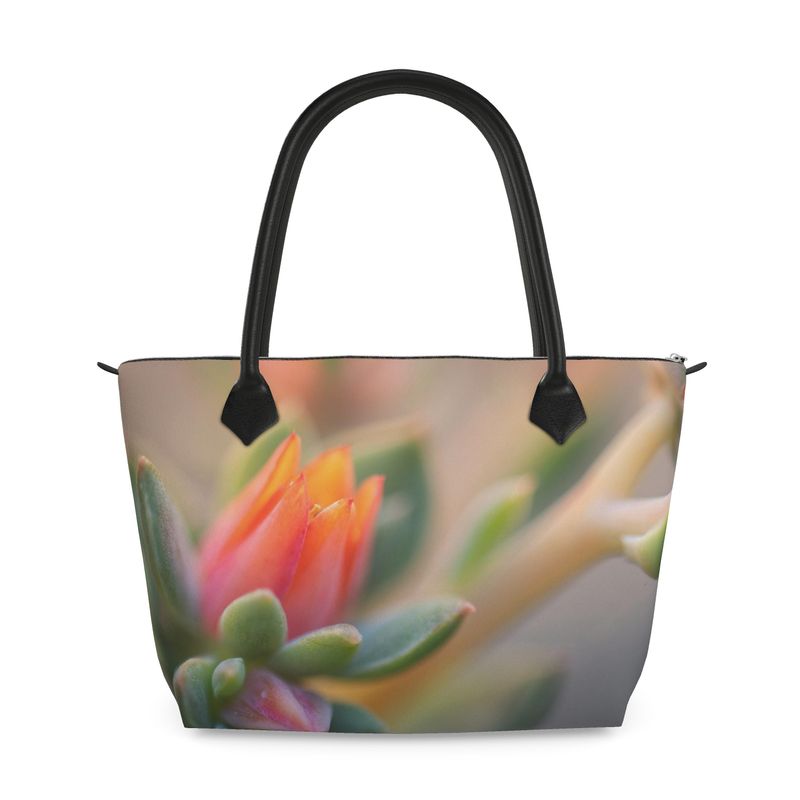 Structured zip top handbag featuring echeveria succulent artwork, leather handles, interior pockets, and 17-inch laptop capacity. Monroe Satin