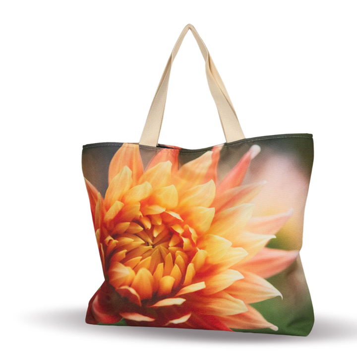 Tote bag with an orange dahlia flower design on a soft green background and light-colored handles