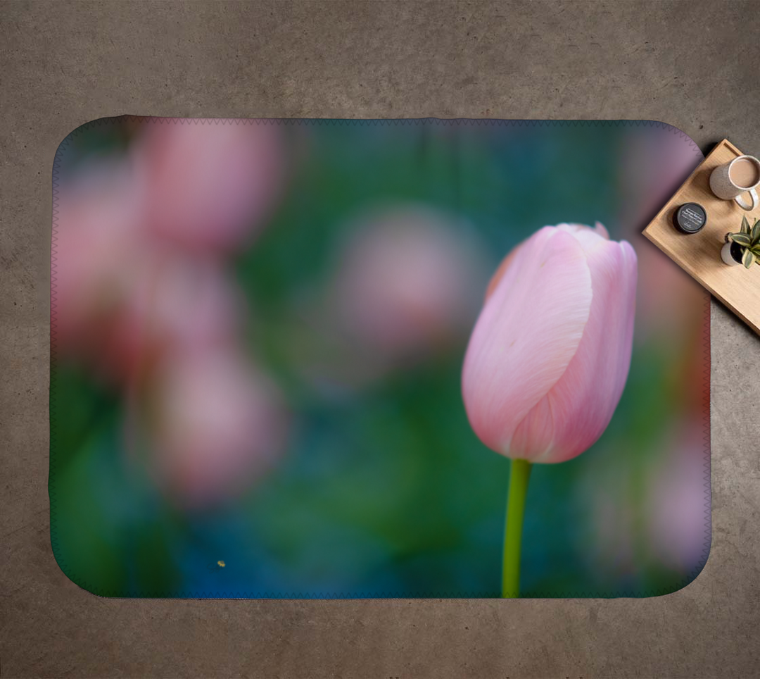 Pink tulip on a decorative mat with a blurred background