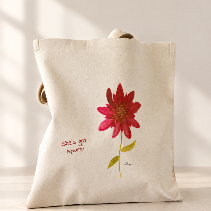 She’s Got Spunk natural canvas tote featuring Sally Halvorsen’s watercolor flower with crimson petals, a golden center, green leaves, and the words “She’s got spunk!”