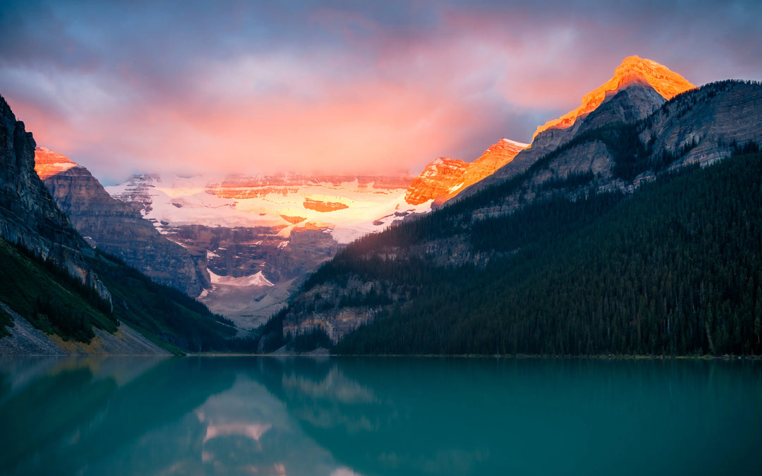 Sunrise over Lake Louise in Banff  National Park captured in glowing alpenglow and reflection. A peaceful fine art landscape photograph printed on archival paper.