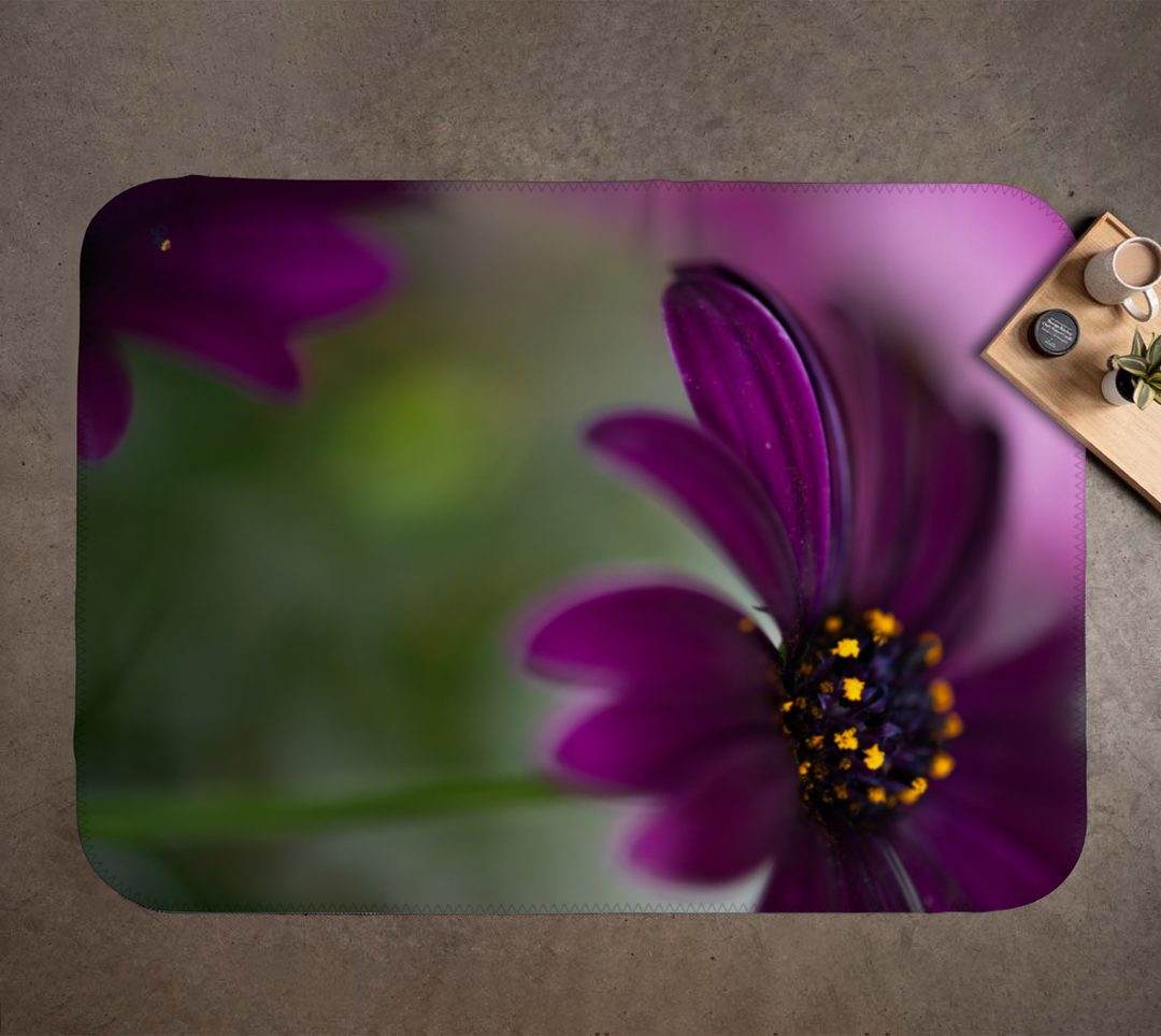 Purple flower design on a rug with a blurred background