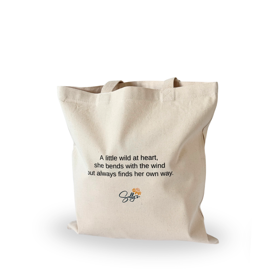 Back of natural canvas tote featuring the inspirational message, “We each flower in our own way, but we are better together.”