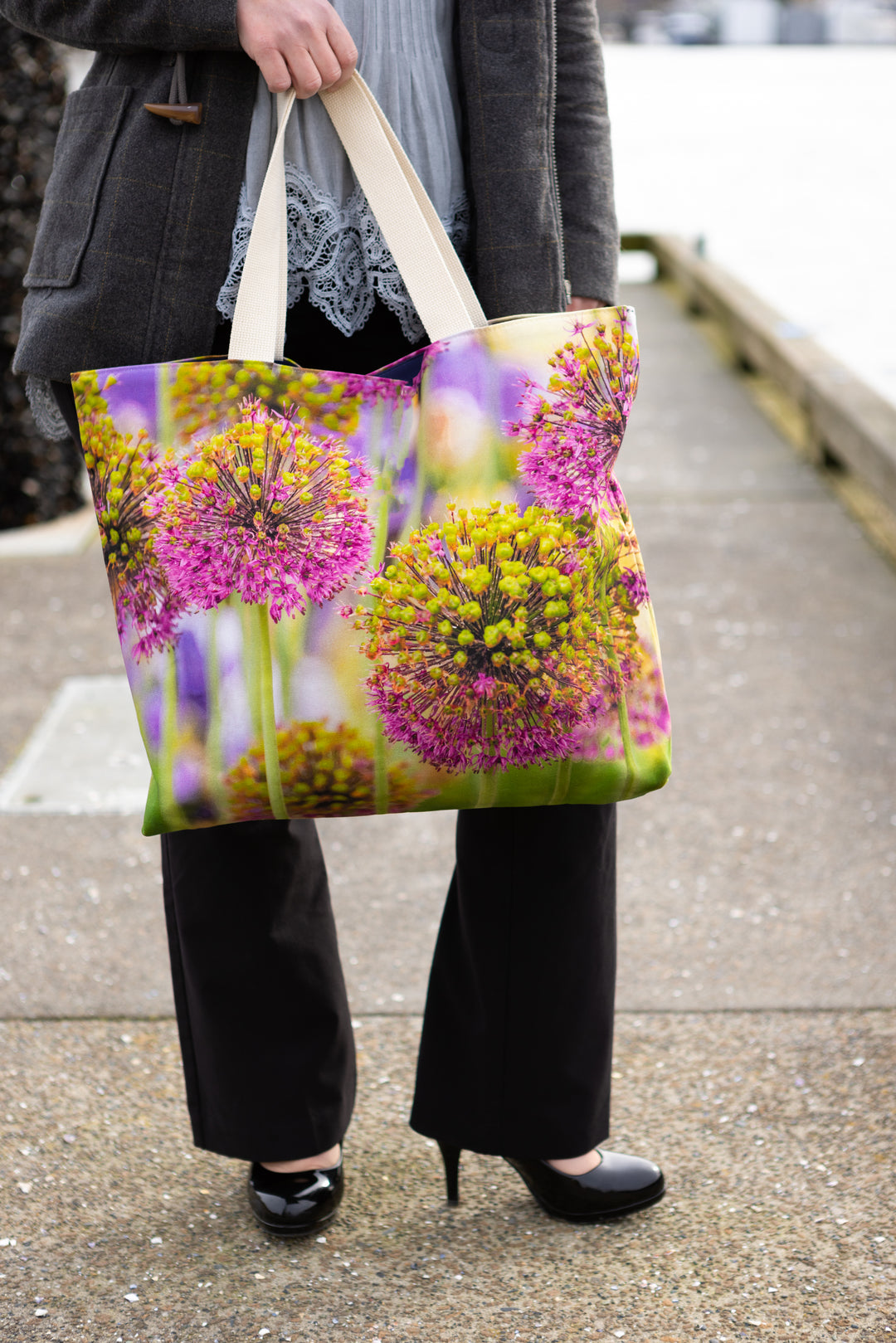 Allium Print Market Tote Bag - being held by model in black slacks and black pumps with a grey jacket, blue top at the wharf